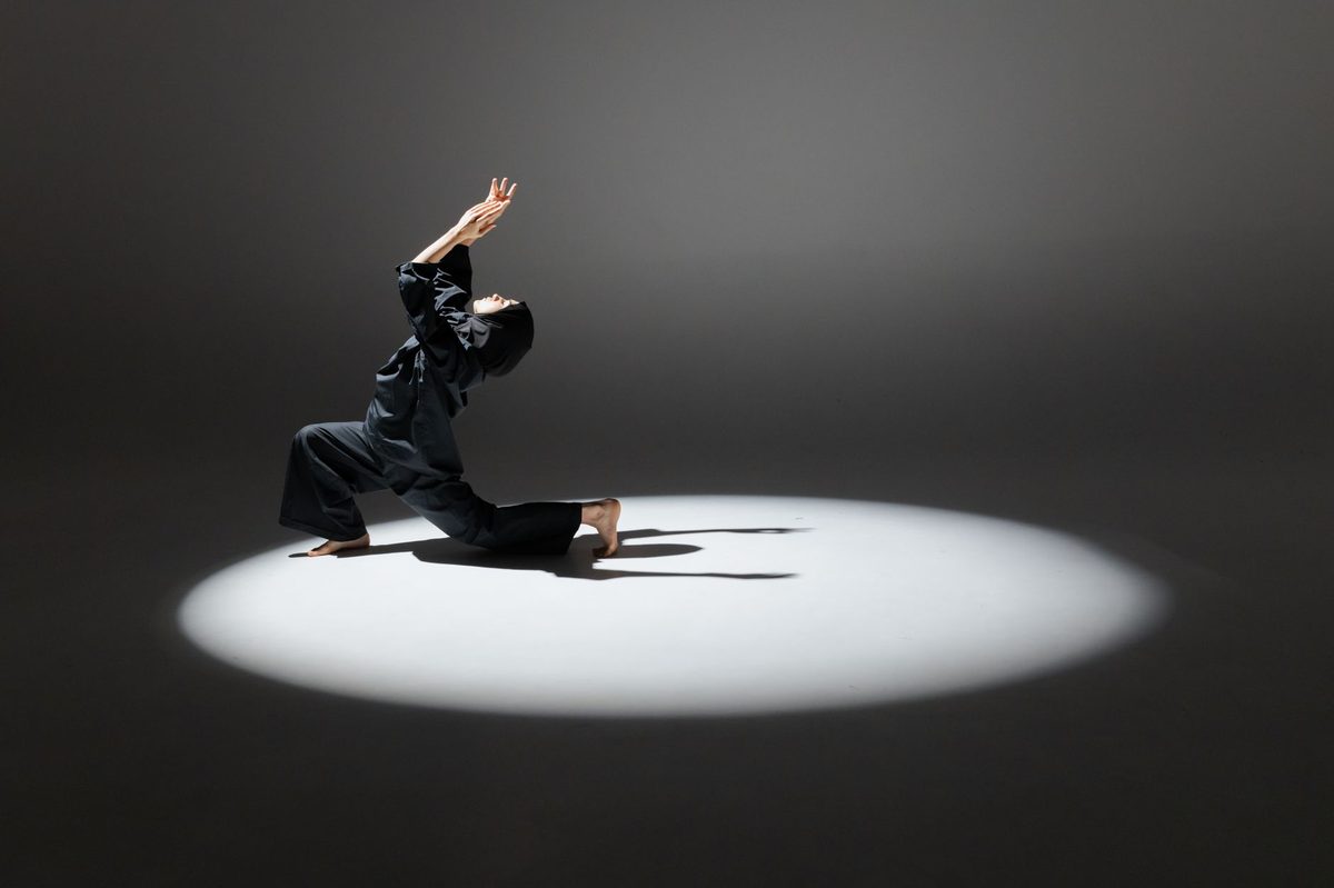Contemporary dance performance under a spotlight, part of the Antigel Festival programme in Geneva