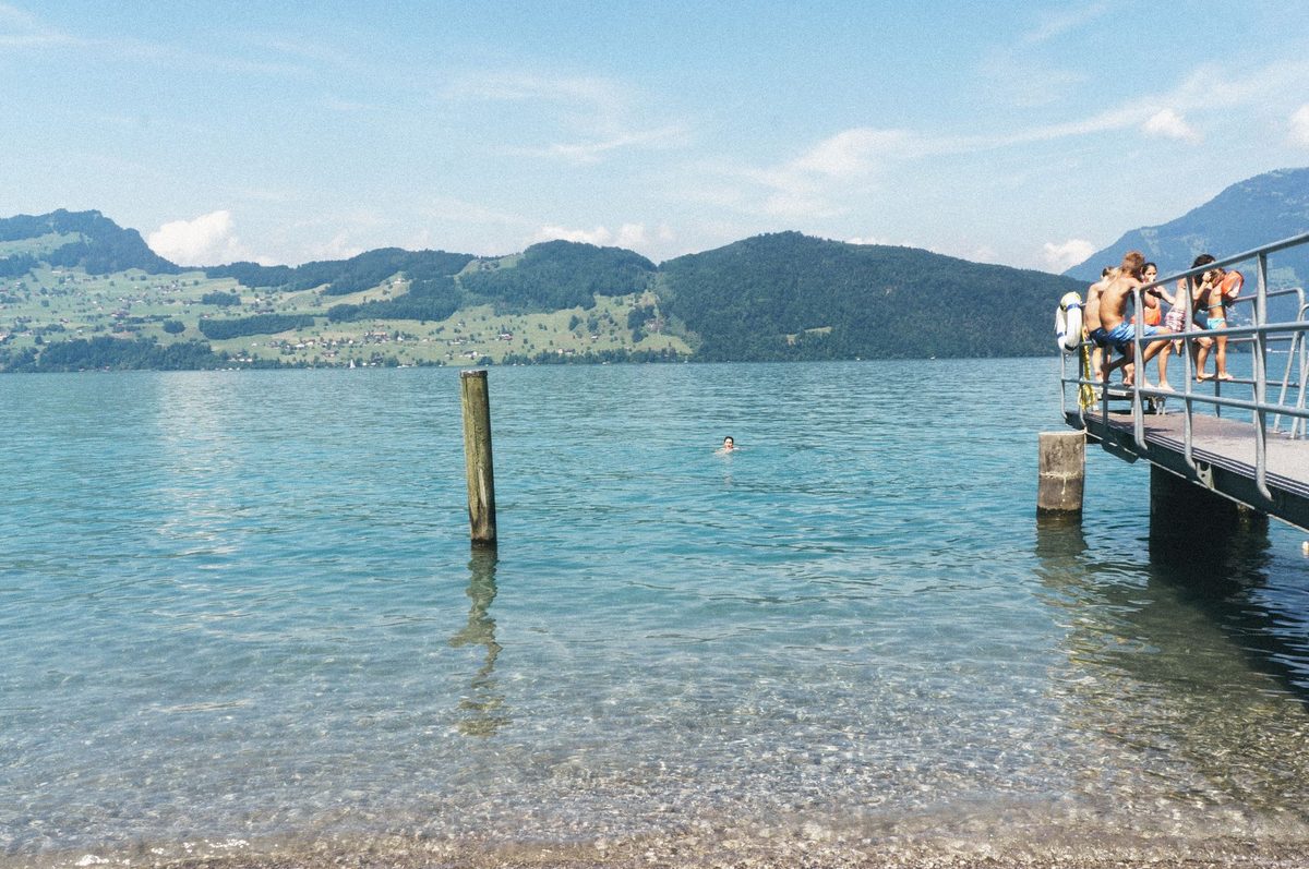 Summer swimmers and divers at a lakeside pier on Lake Geneva in Geneva