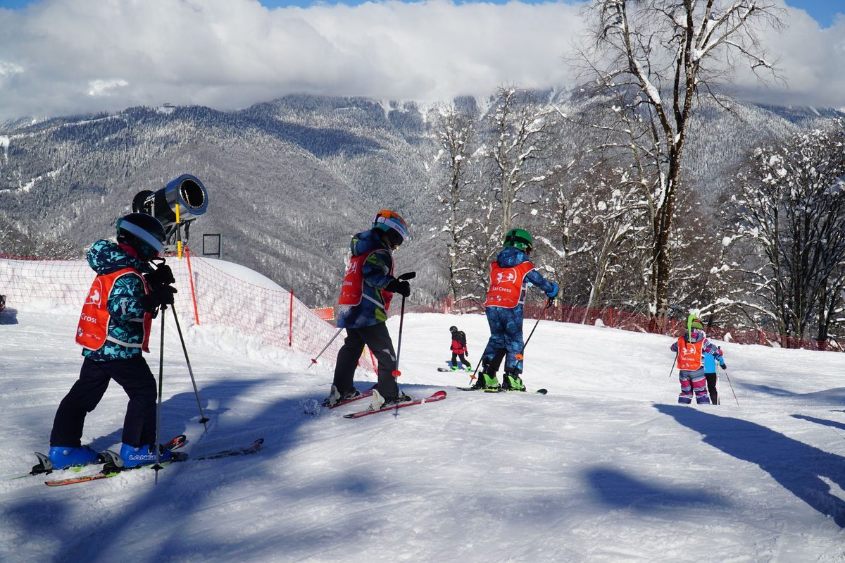 A family skiing a gentle Alpine slope, the kind of terrain near Geneva for beginners