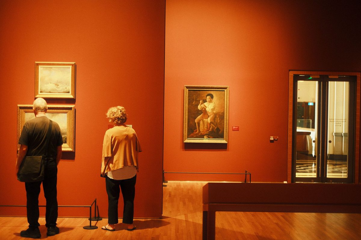 Visitors viewing paintings inside a Geneva art museum