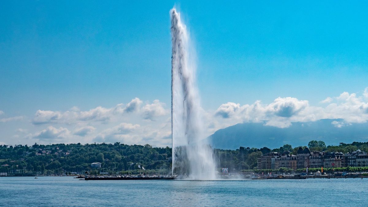Geneva's lakefront and Jet d'Eau busy with people on a summer evening