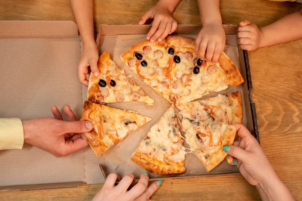 Children eating pizza at an Italian restaurant like Luigia in Geneva