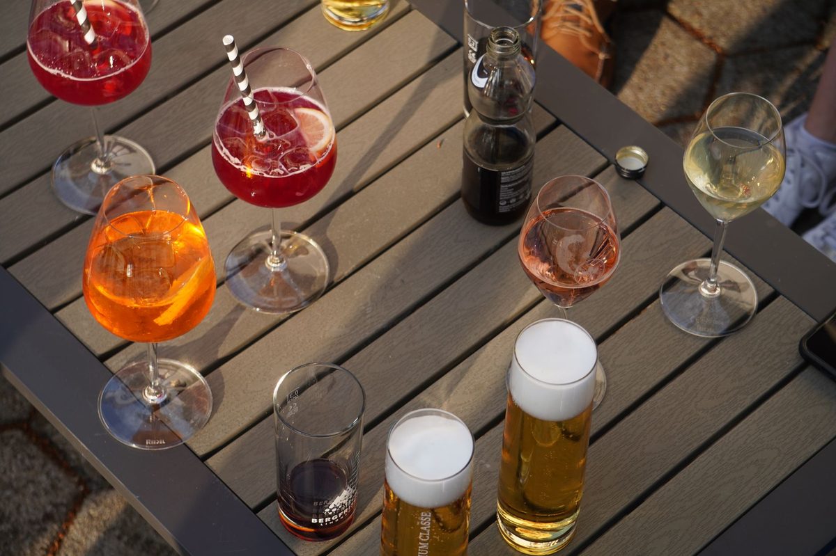 Friends sharing an apero of wine and beer on a Geneva terrace at early evening