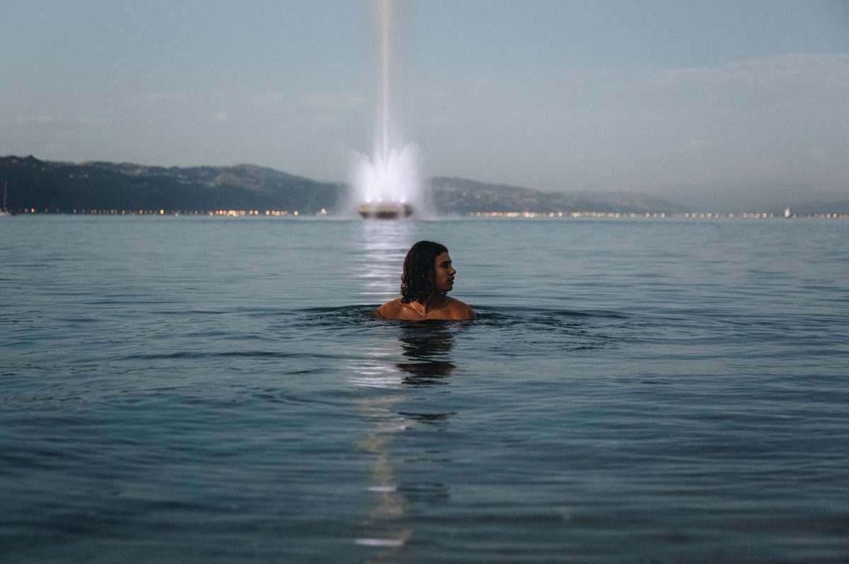 Swimmers in Lake Geneva on a summer day with the Geneva waterfront behind, a top Geneva outdoor activity