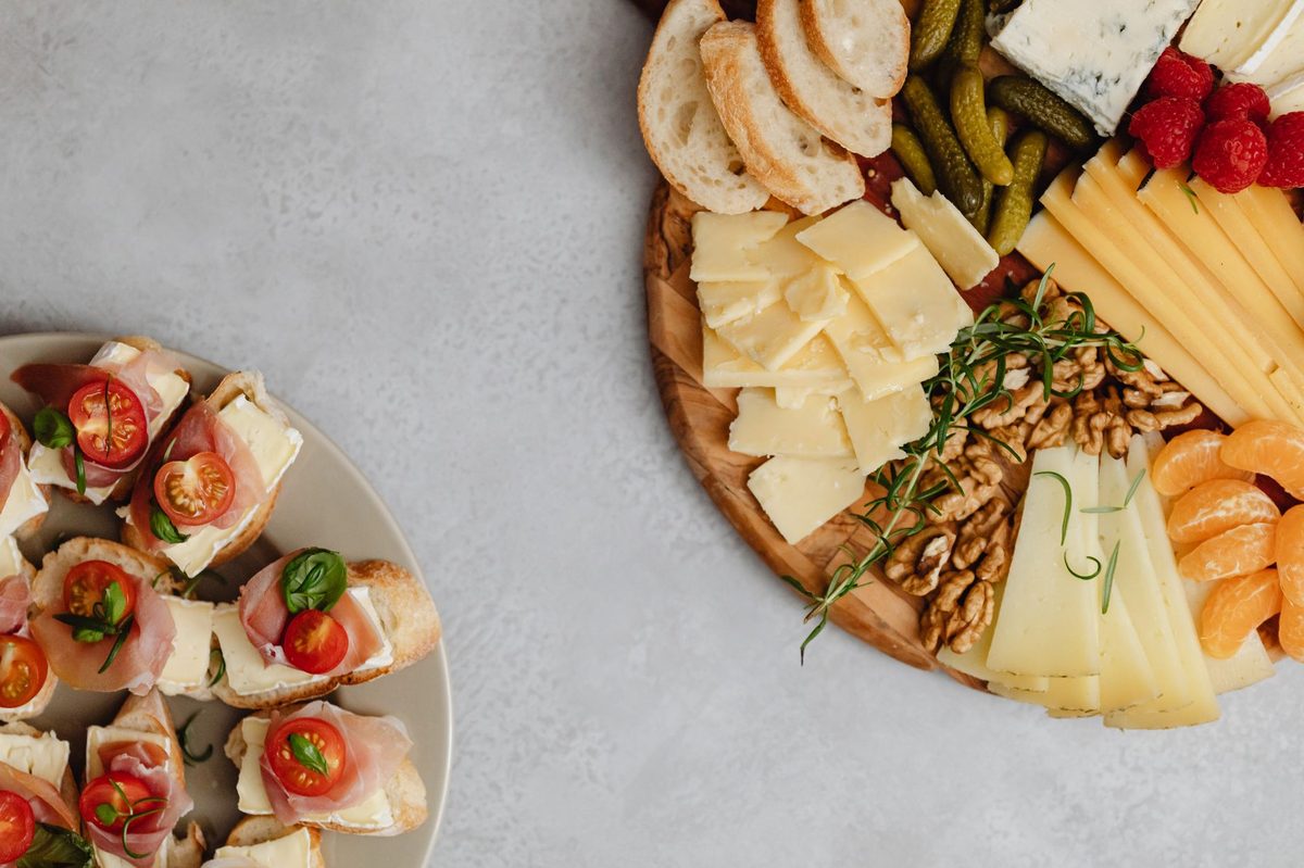 A raclette plate with potatoes, cornichons, pickled onions and dried meat