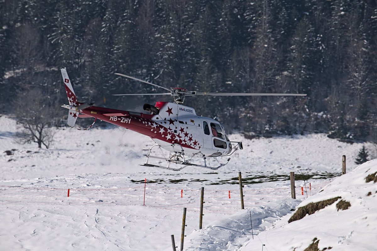 A rescue helicopter over the Alps, the REGA service that Geneva travel insurance should cover