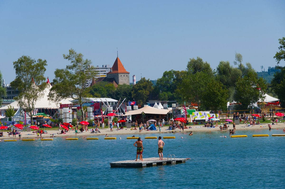 Geneva lakefront packed with swimmers and sunbathers on a summer day