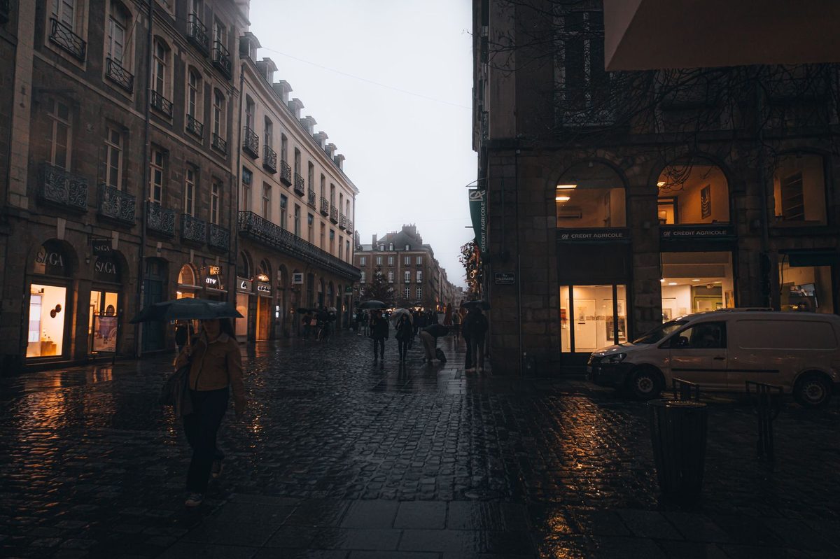 A wet, rainy street in Geneva with an umbrella