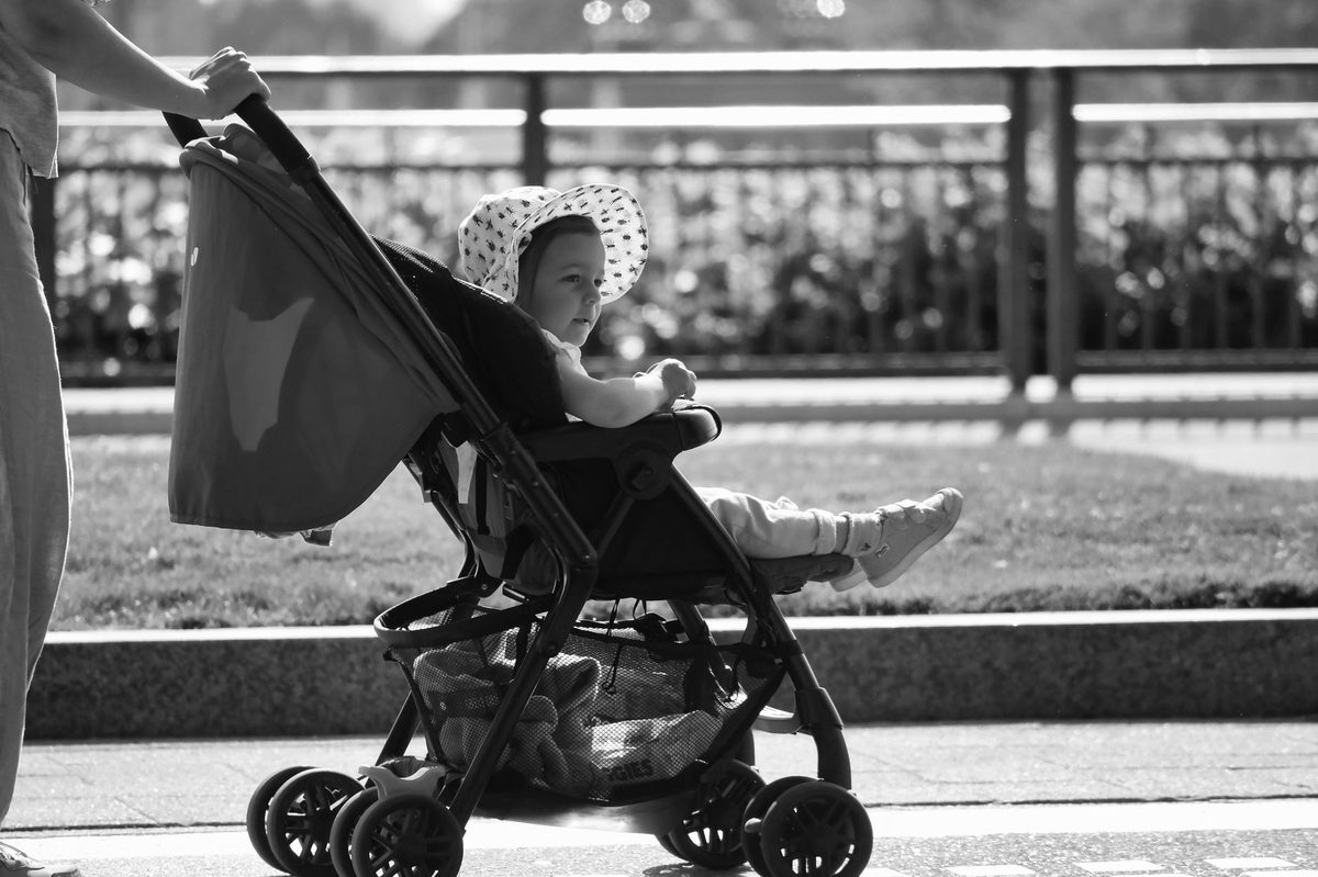 Parents pushing a toddler in a stroller through Geneva, a toddler-friendly city