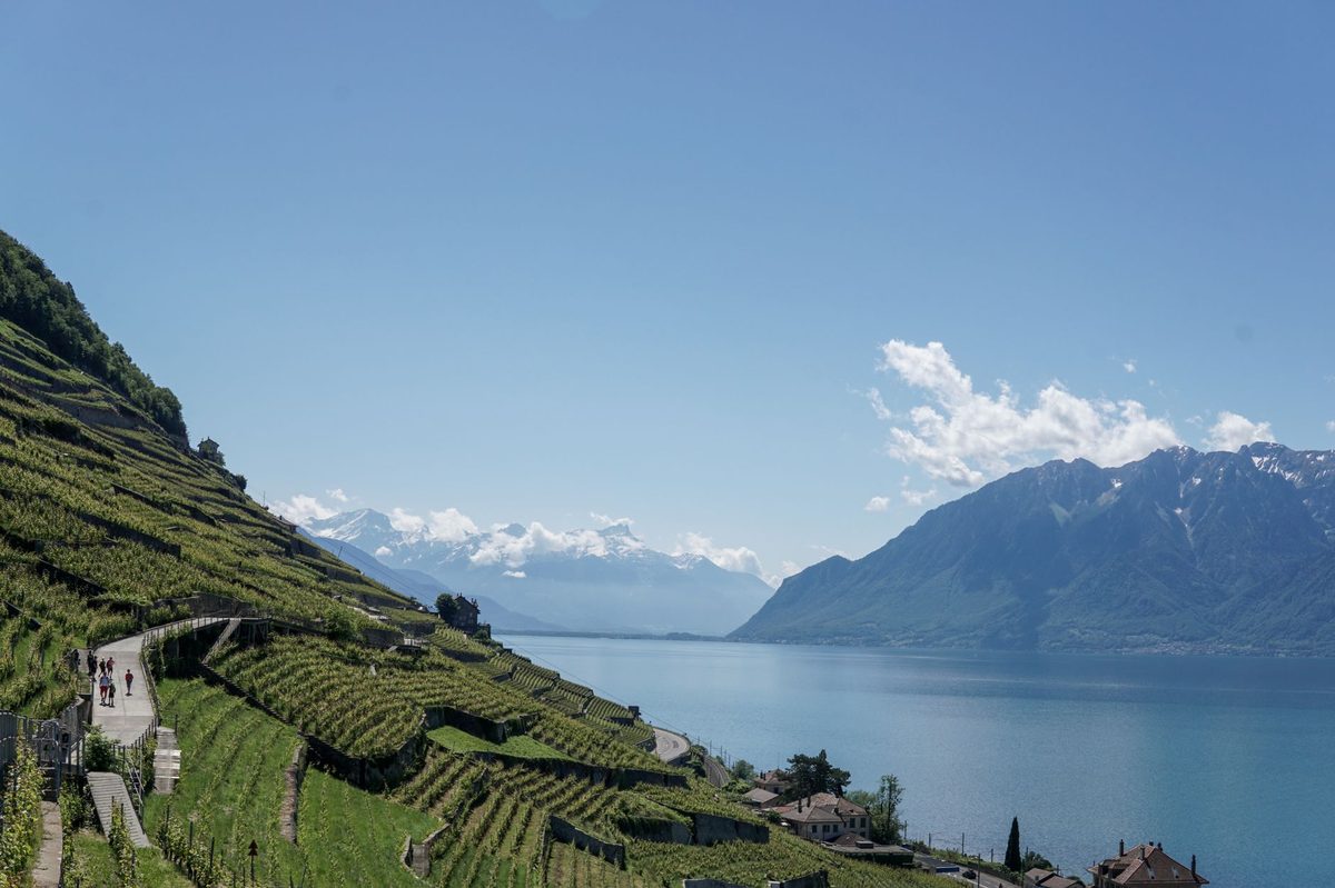Hikers on an Alpine trail near Geneva with mountain views toward Mont Blanc