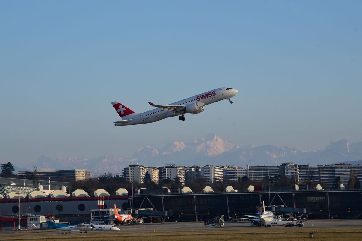 Geneva Airport terminal with a plane and the Alps behind, beside the best hotels near Geneva airport