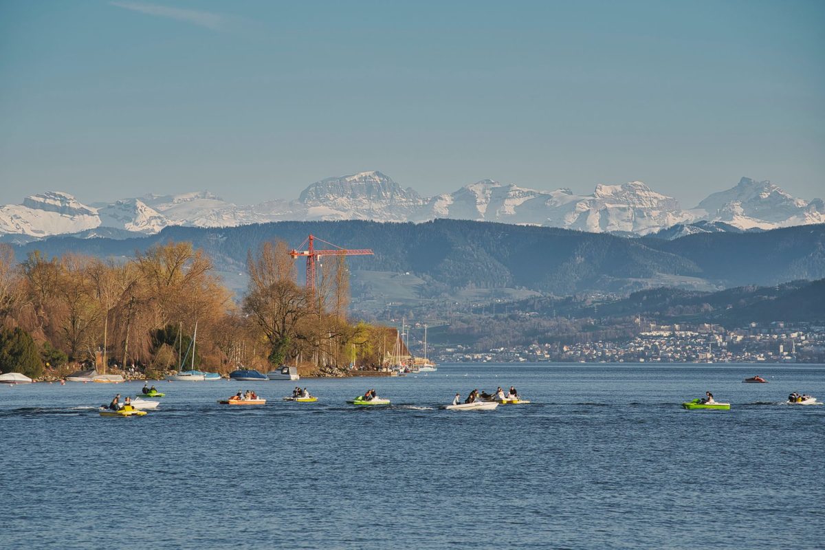 Kayakers paddling on Lake Geneva with the Alps behind near Geneva