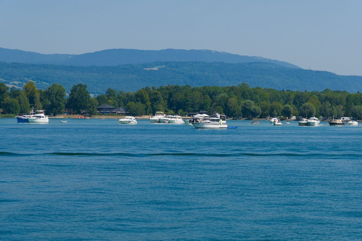 Clear water of Lake Geneva with a mountain backdrop beyond the city beaches