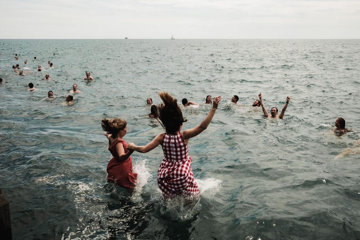 Families swimming and paddling at a Lake Geneva beach in summer
