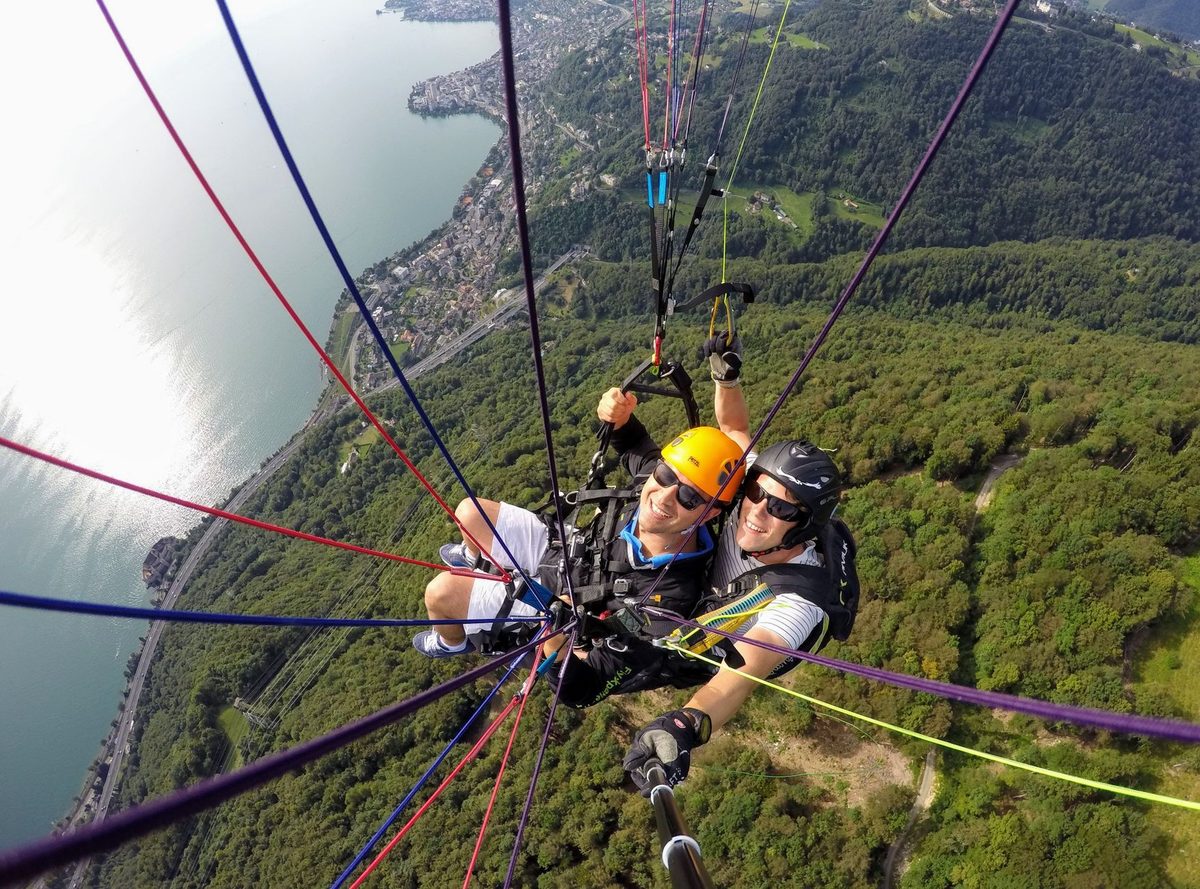 A tandem paraglider launching off Mont Saleve above the Geneva basin