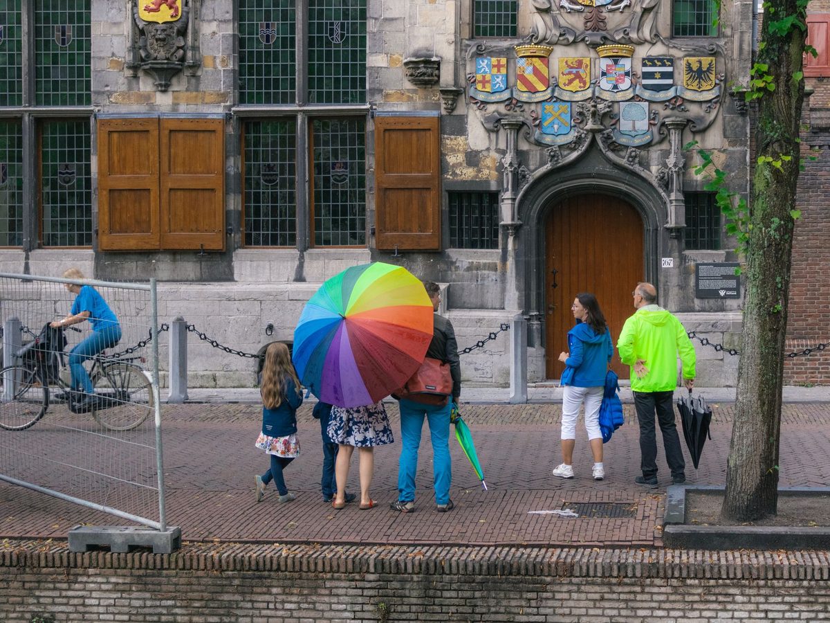 A family with umbrellas on a rainy Geneva street