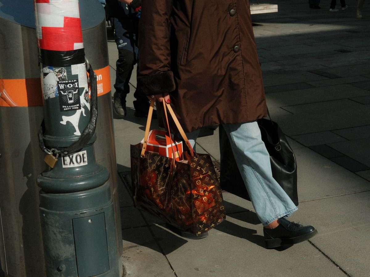 Shopper carrying luxury shopping bags after a Rue du Rhone half-day in Geneva