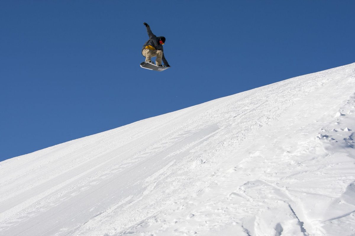 Snowboarder in deep powder at an Alpine snowpark within day-trip range of Geneva