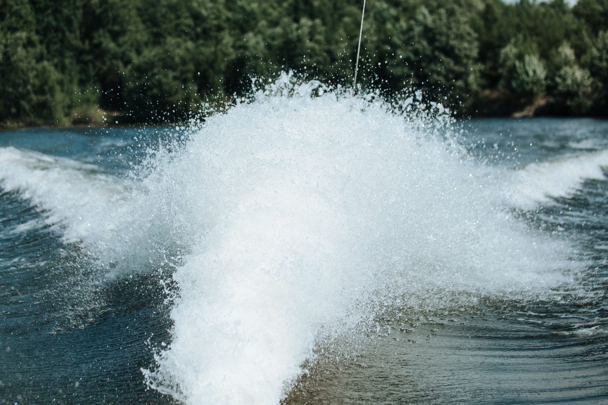 Wakeboarder carving behind a boat on Lake Geneva water sports