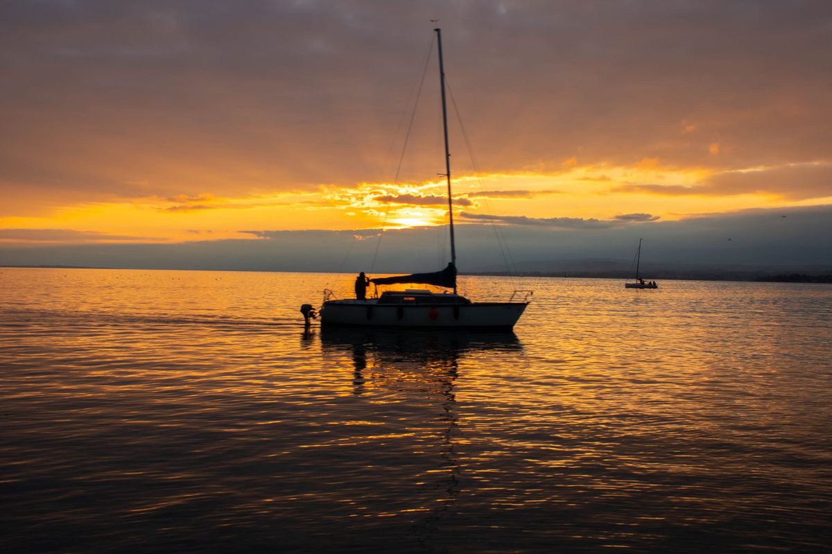 Sailing boat on Lake Geneva at sunset, the heart of Geneva water sports