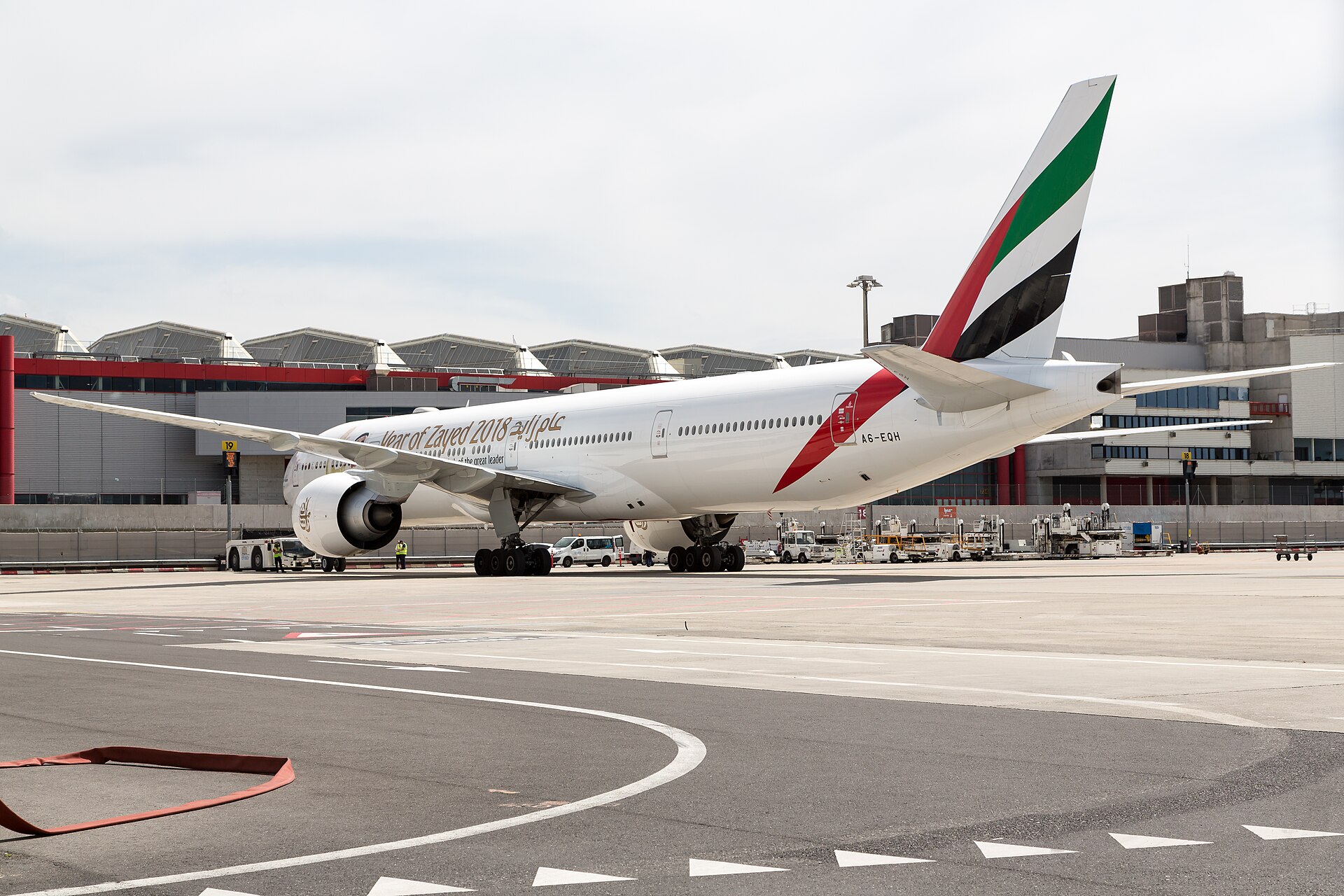 An Emirates Boeing 777 parked on the apron in front of the Geneva Airport terminal