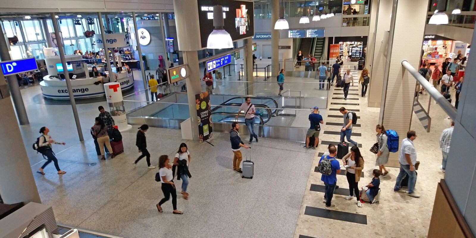 Passengers with luggage in the arrivals hall of Geneva Airport, the departure point for Alpine ski transfers