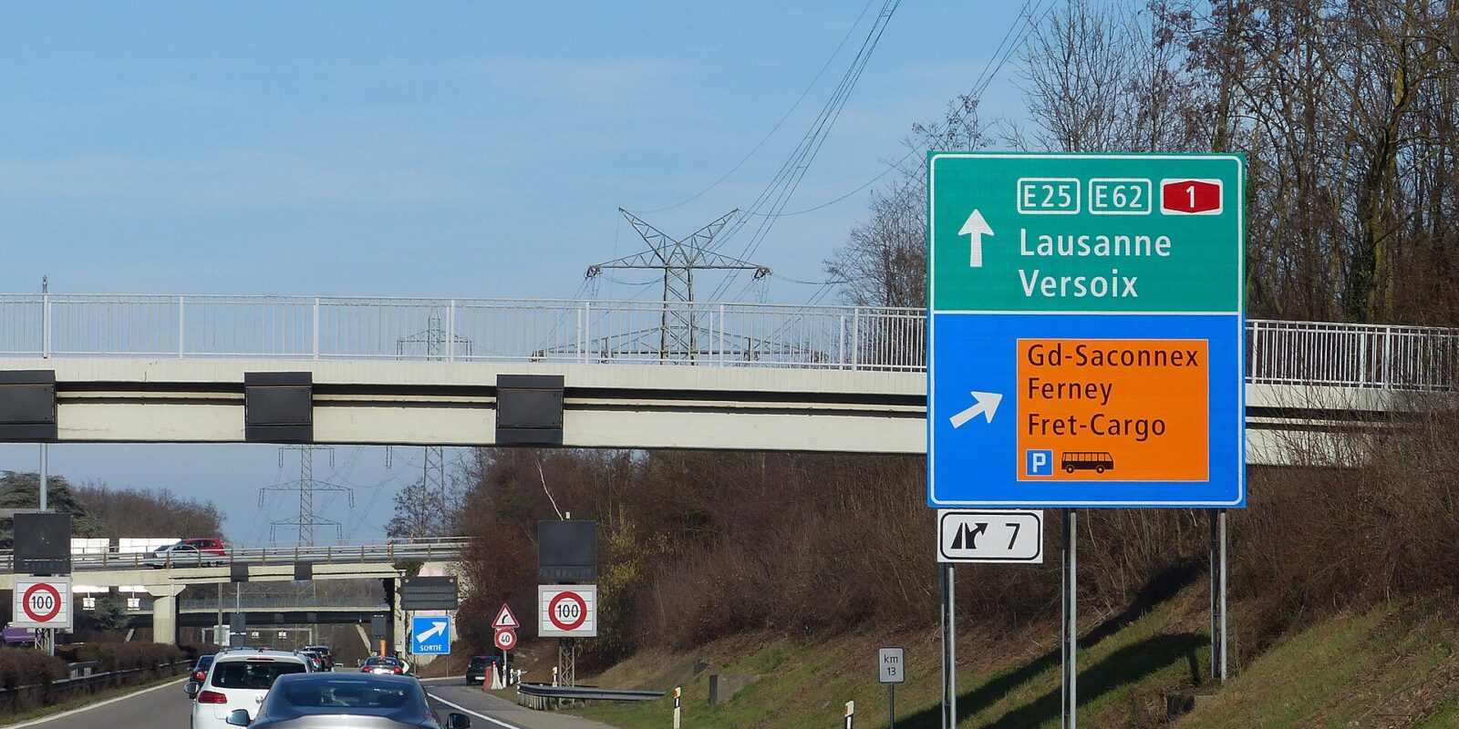 Motorway sign for exit 7 on the Swiss A1 beside Geneva Airport, pointing to Grand-Saconnex, Ferney and the cargo area