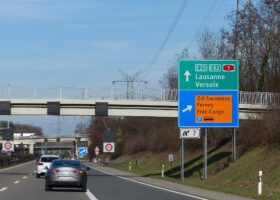 Motorway sign for exit 7 on the Swiss A1 beside Geneva Airport, pointing to Grand-Saconnex, Ferney and the cargo area