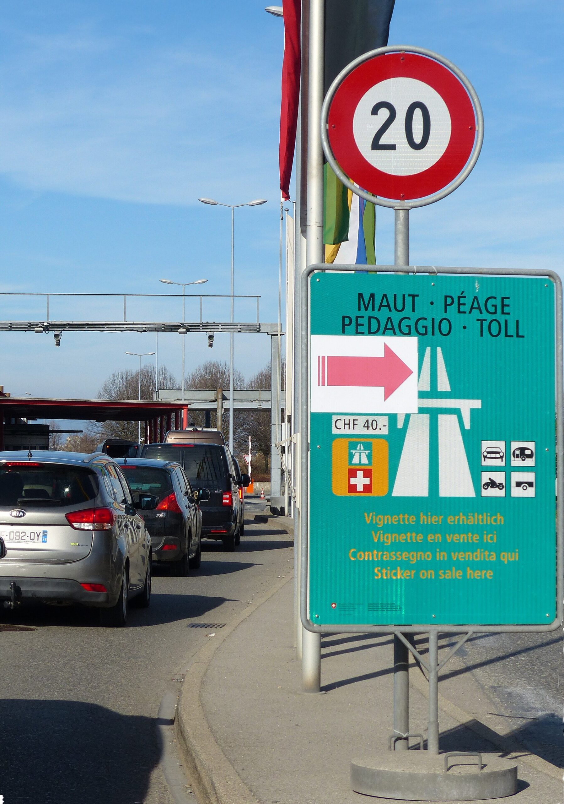 Sign at the Bardonnex customs post selling the Swiss motorway vignette for CHF 40, with cars queueing at the border
