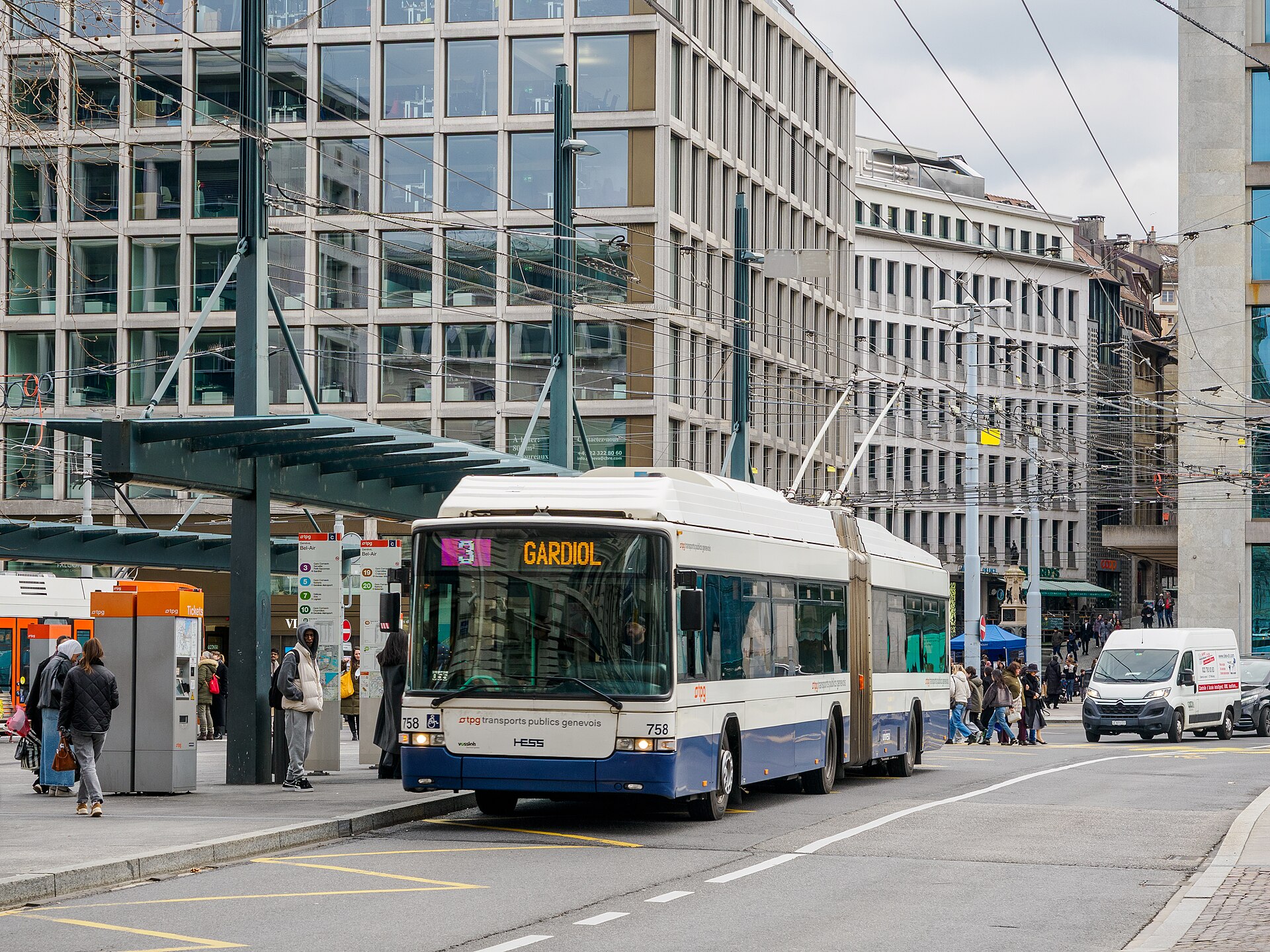A tpg trolleybus on line 3 at the Bel-Air stop in Geneva, with orange ticket machines beside the shelter