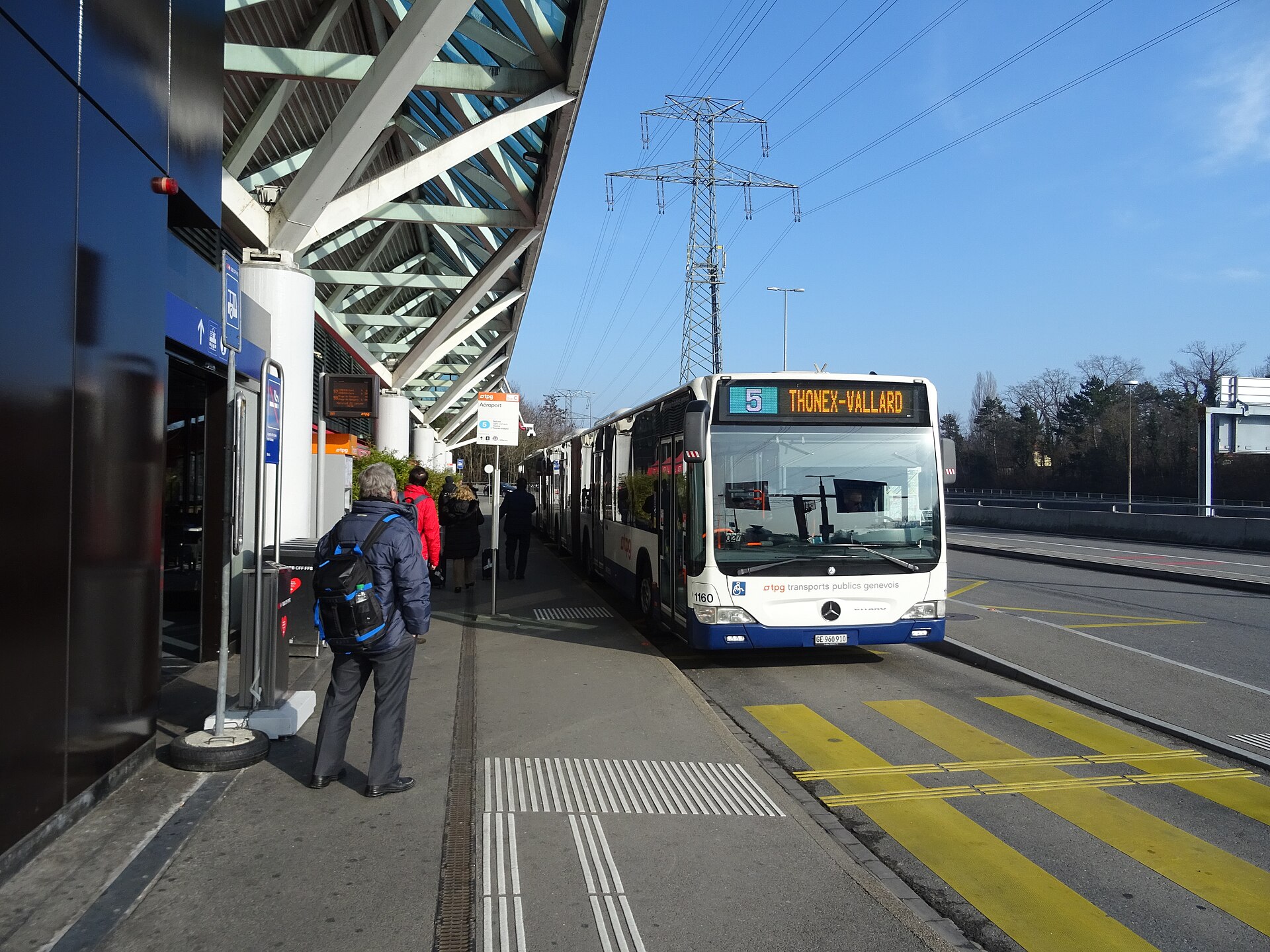 A TPG articulated bus on route 5 waiting at the Geneva Airport stop with passengers boarding