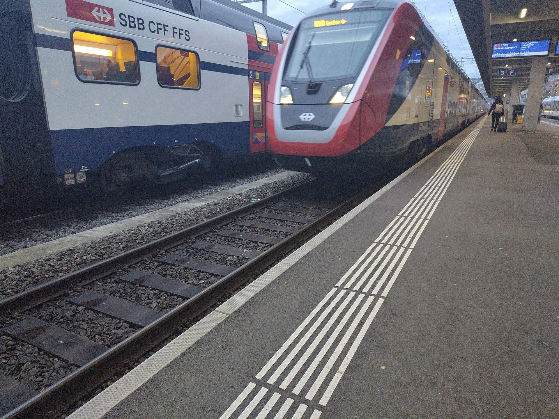 A Swiss intercity train at a platform, with the display showing Genève-Aéroport as its destination