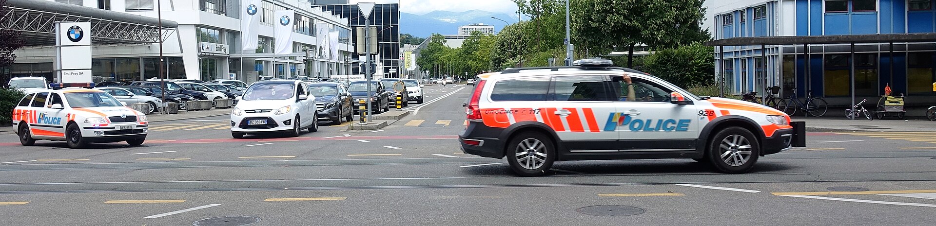 Two Geneva cantonal police cars at a road junction in the city