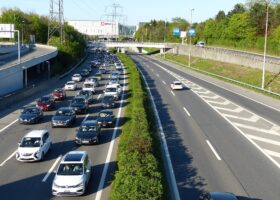Queuing traffic on the A1 motorway at the Geneva Airport junction with the Palexpo hall behind