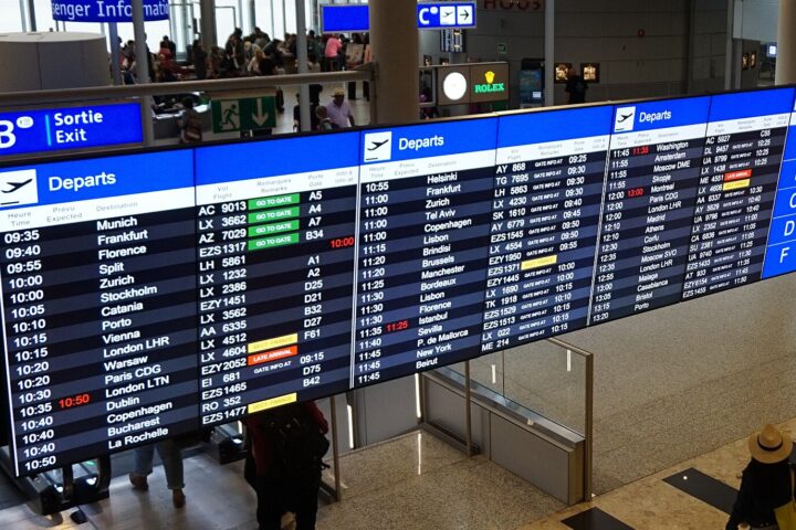Geneva Airport departure boards showing flights and a walking-time panel for gates A, B, C, D and F