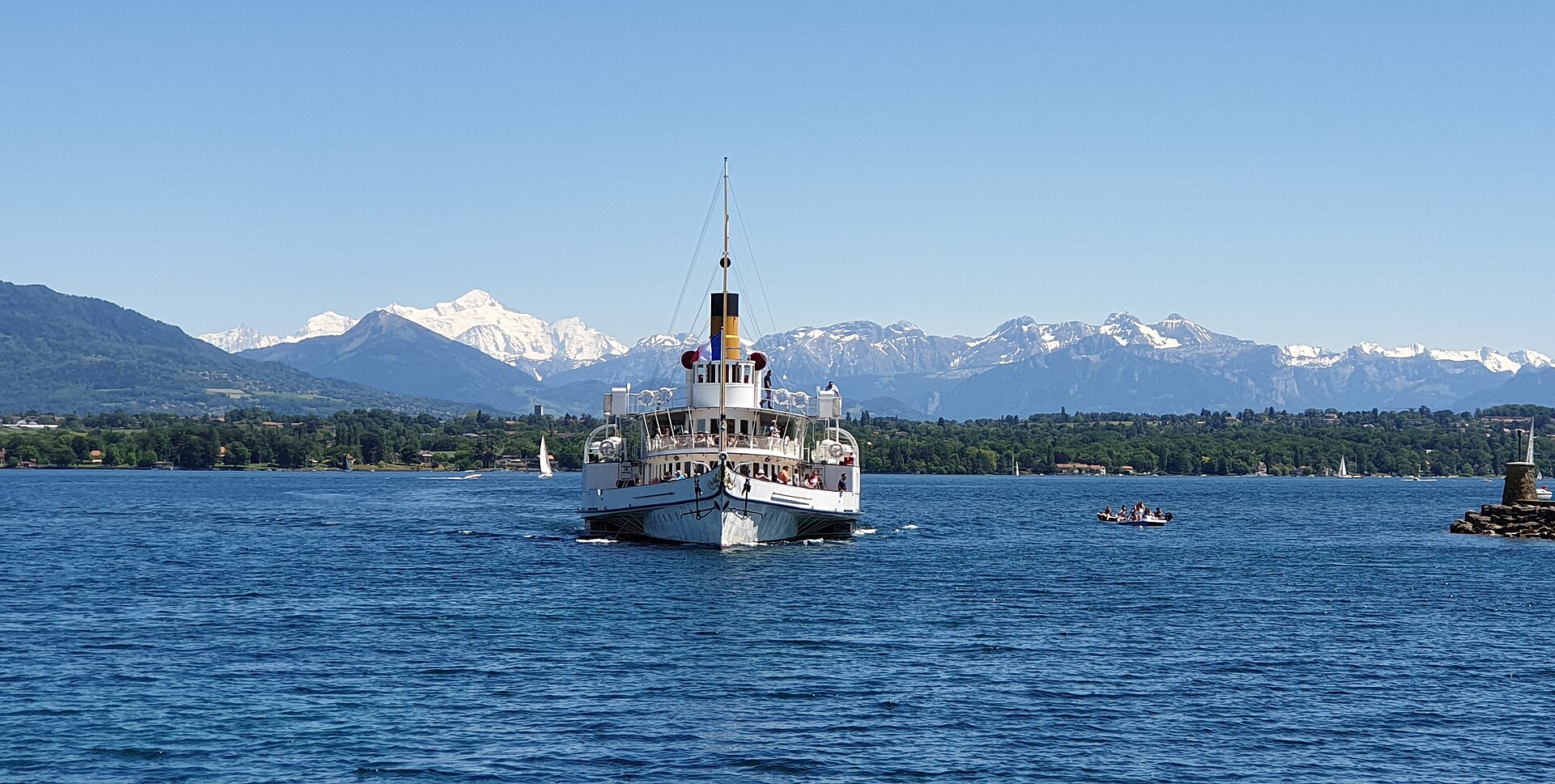 The Belle Époque paddle steamer Savoie sailing across Lake Geneva towards the camera, with the snow-covered Mont Blanc massif behind
