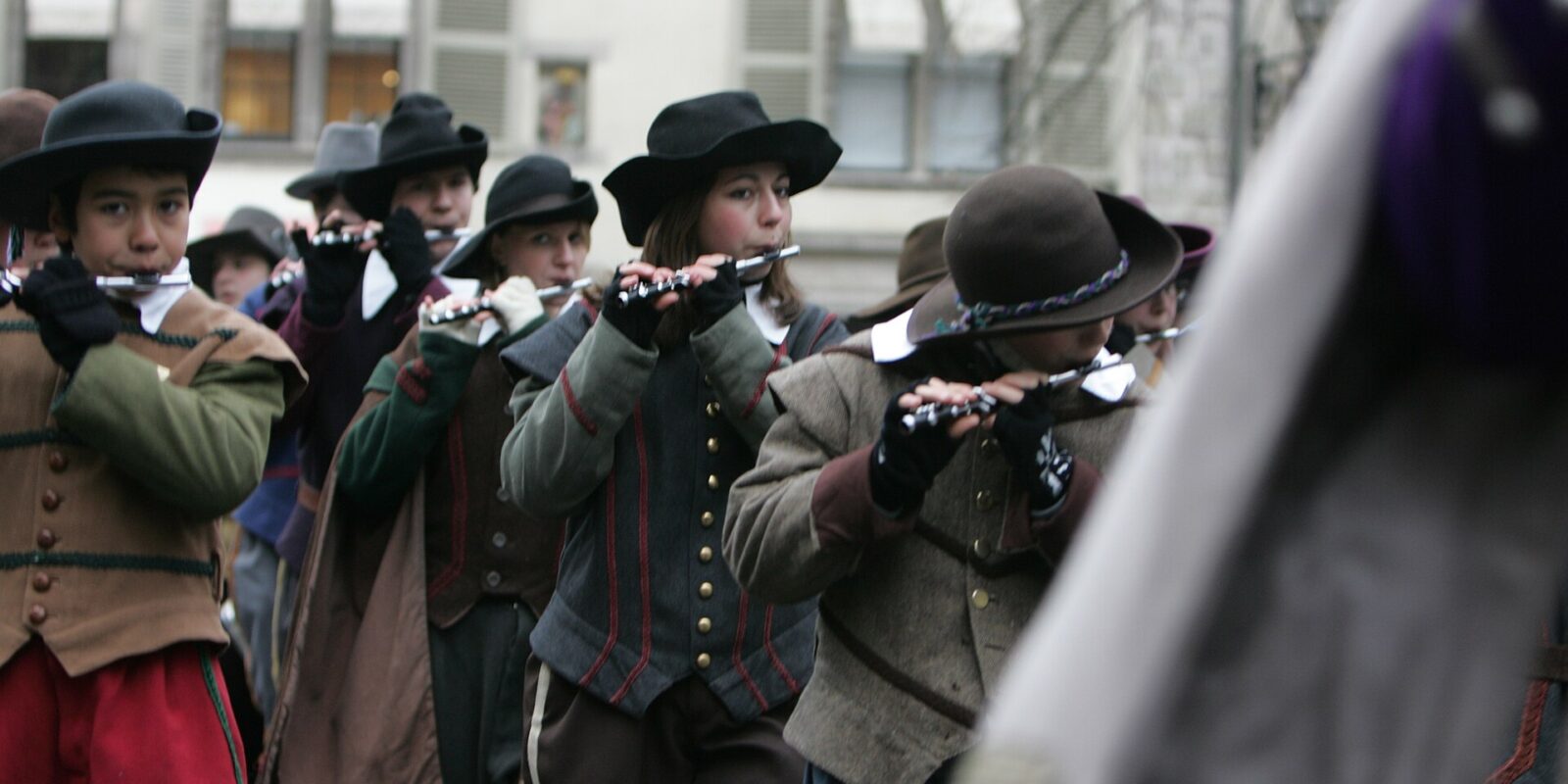 Young fifers in seventeenth-century costume and felt hats playing in the Escalade procession in Geneva's Old Town