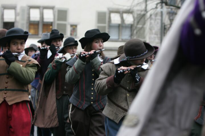 Young fifers in seventeenth-century costume and felt hats playing in the Escalade procession in Geneva's Old Town