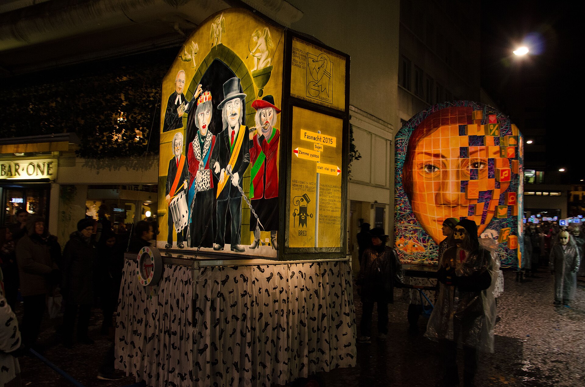 Large painted and illuminated lanterns displayed in a Basel street at night during Fasnacht