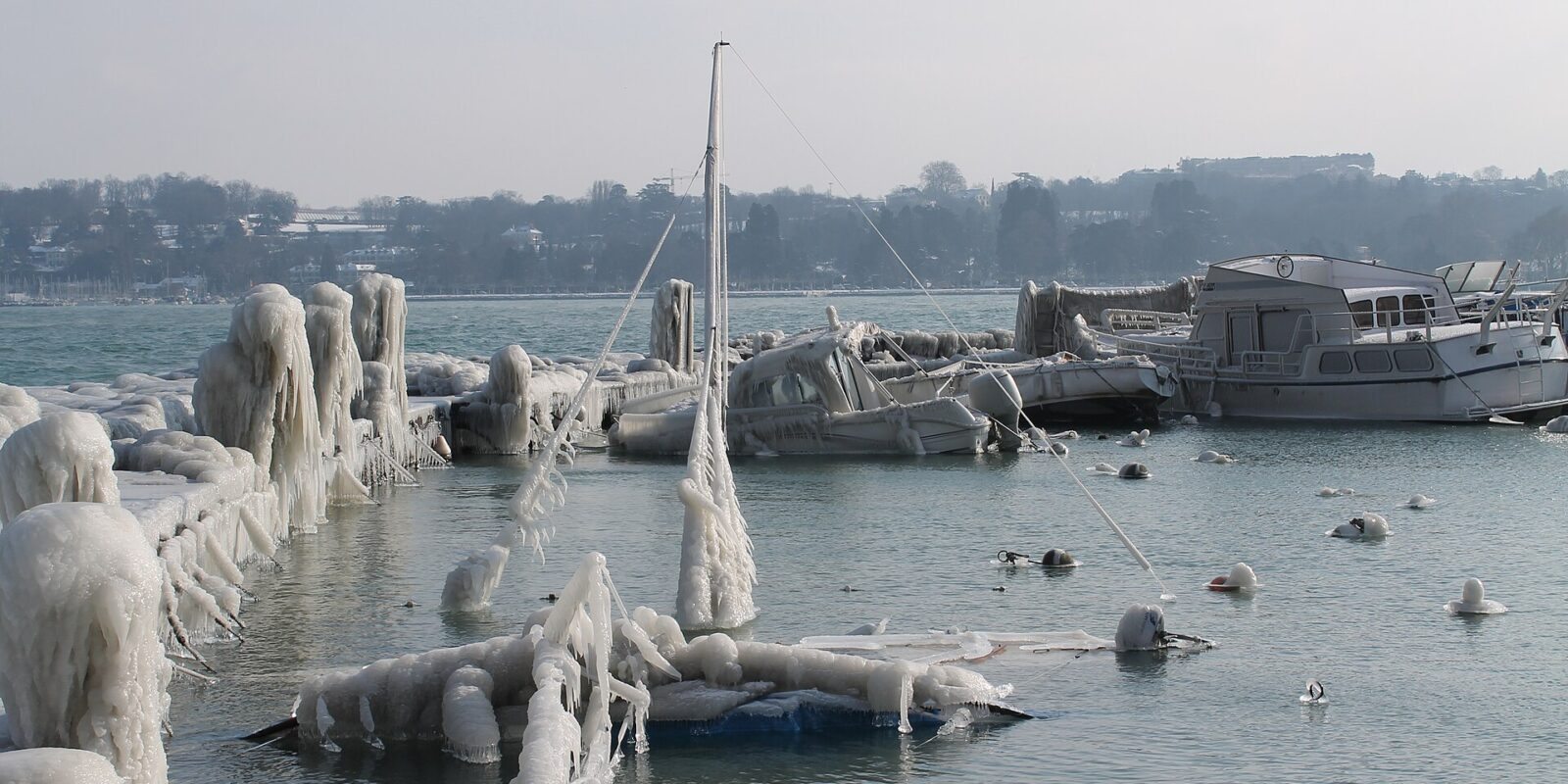Boats, masts and mooring posts encased in thick ice from Bise spray in Geneva harbour during the February 2012 cold snap