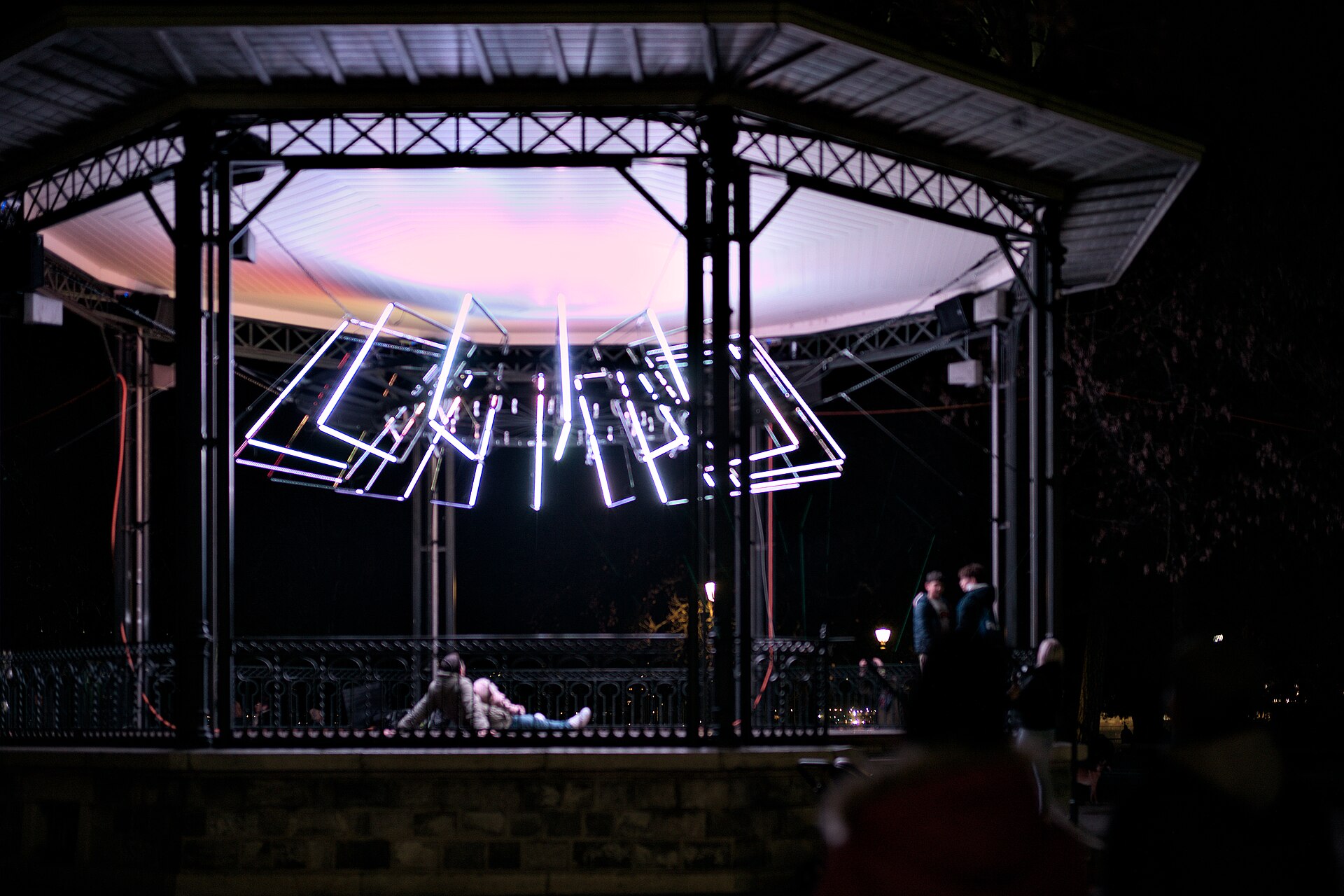 A glowing light installation of white neon frames at night during Geneva Lux