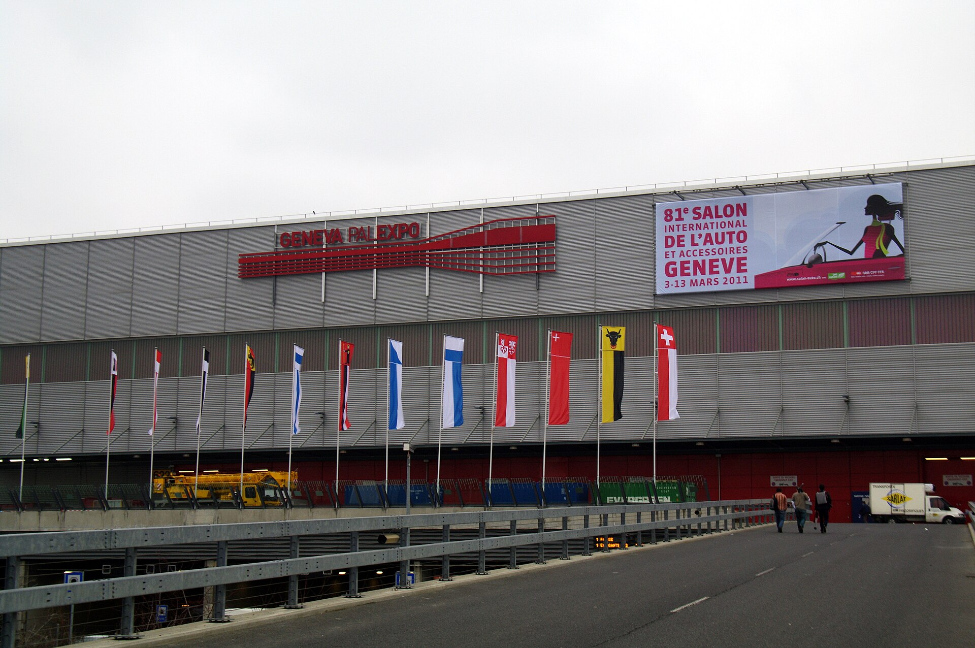 The Geneva Palexpo exhibition hall with a banner for the 81st Geneva motor show in March 2011 and a row of Swiss cantonal flags