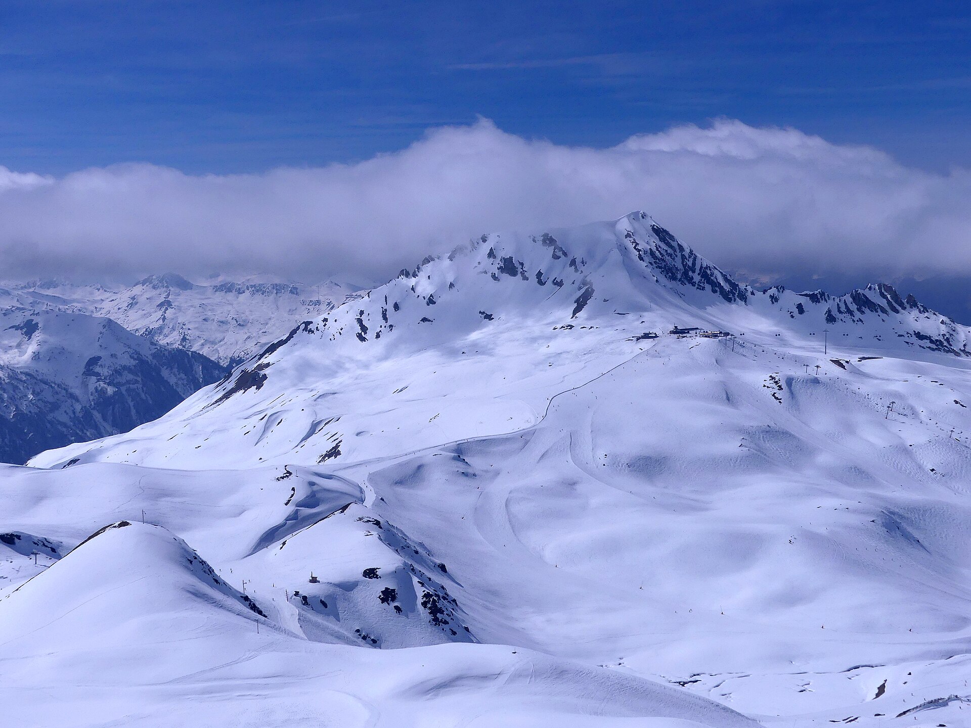 The snow-covered Aiguille Grive and Col de la Chal ski area above Les Arcs under a blue sky in March