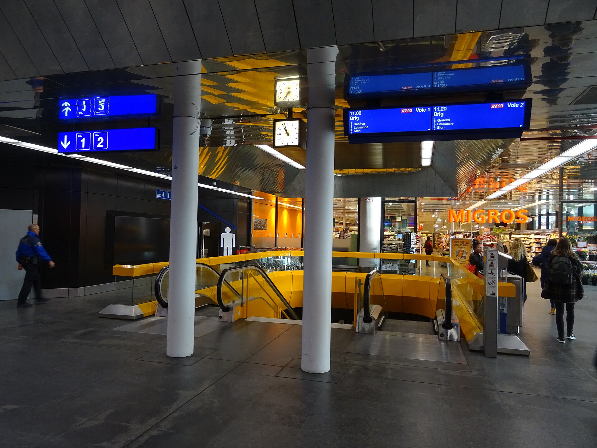 The concourse of Geneva Airport railway station with departure boards for platforms one and two