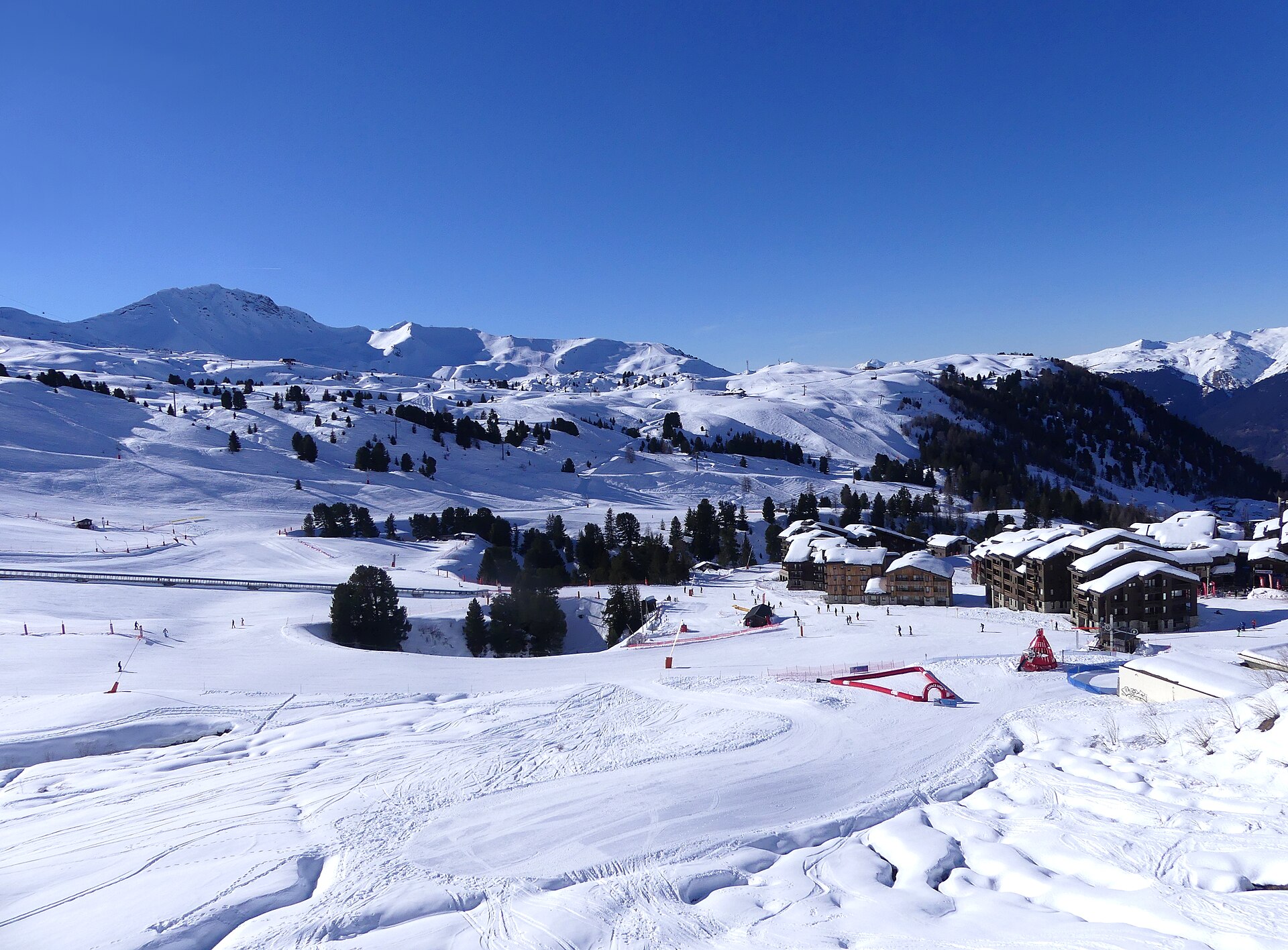 Belle Plagne apartment buildings under snow with the La Plagne pistes rising behind