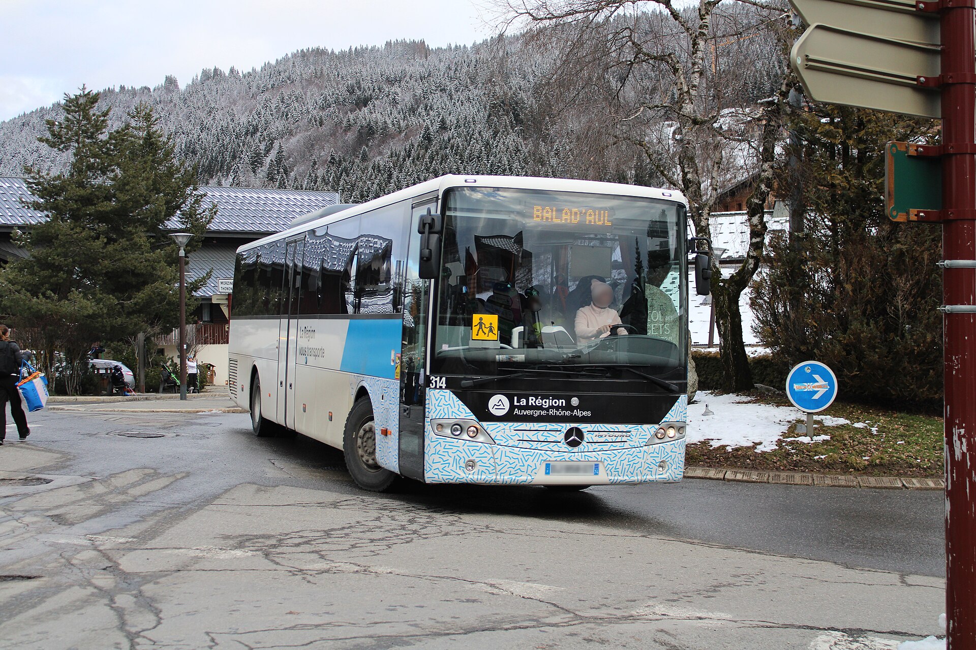 A regional Auvergne-Rhône-Alpes coach parked at Les Gets on a snowy February day, with forested slopes behind