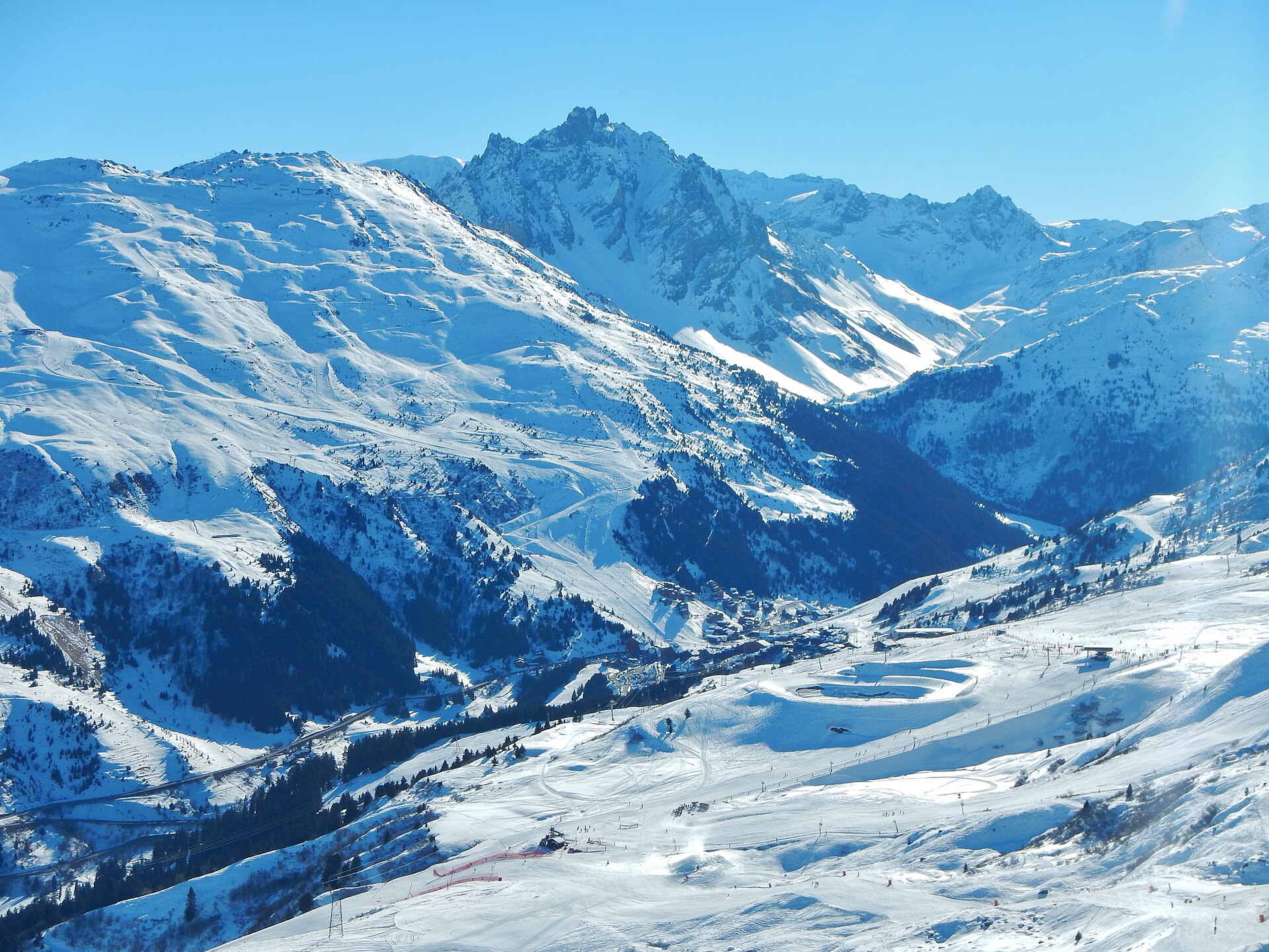 Méribel-Mottaret at the head of the snow-covered valley, with pistes and the access road below