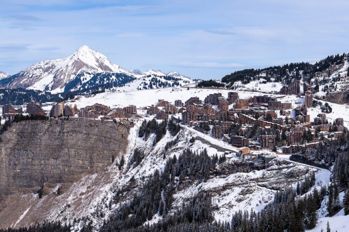 Avoriaz seen across the valley in winter, its apartment blocks perched on top of a cliff above snow-covered slopes