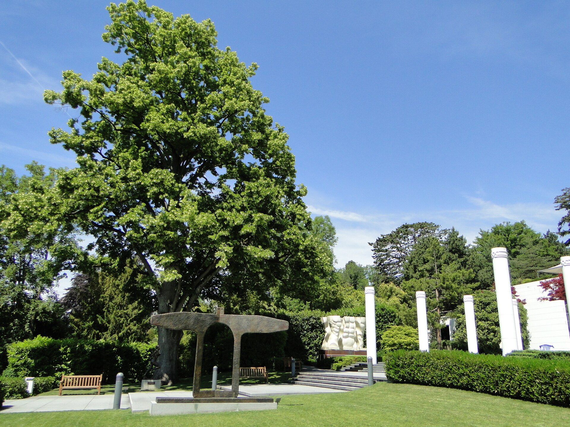 Bronze sculptures, white columns and paved paths sit among lawns and trees in the Olympic Museum park in Lausanne.