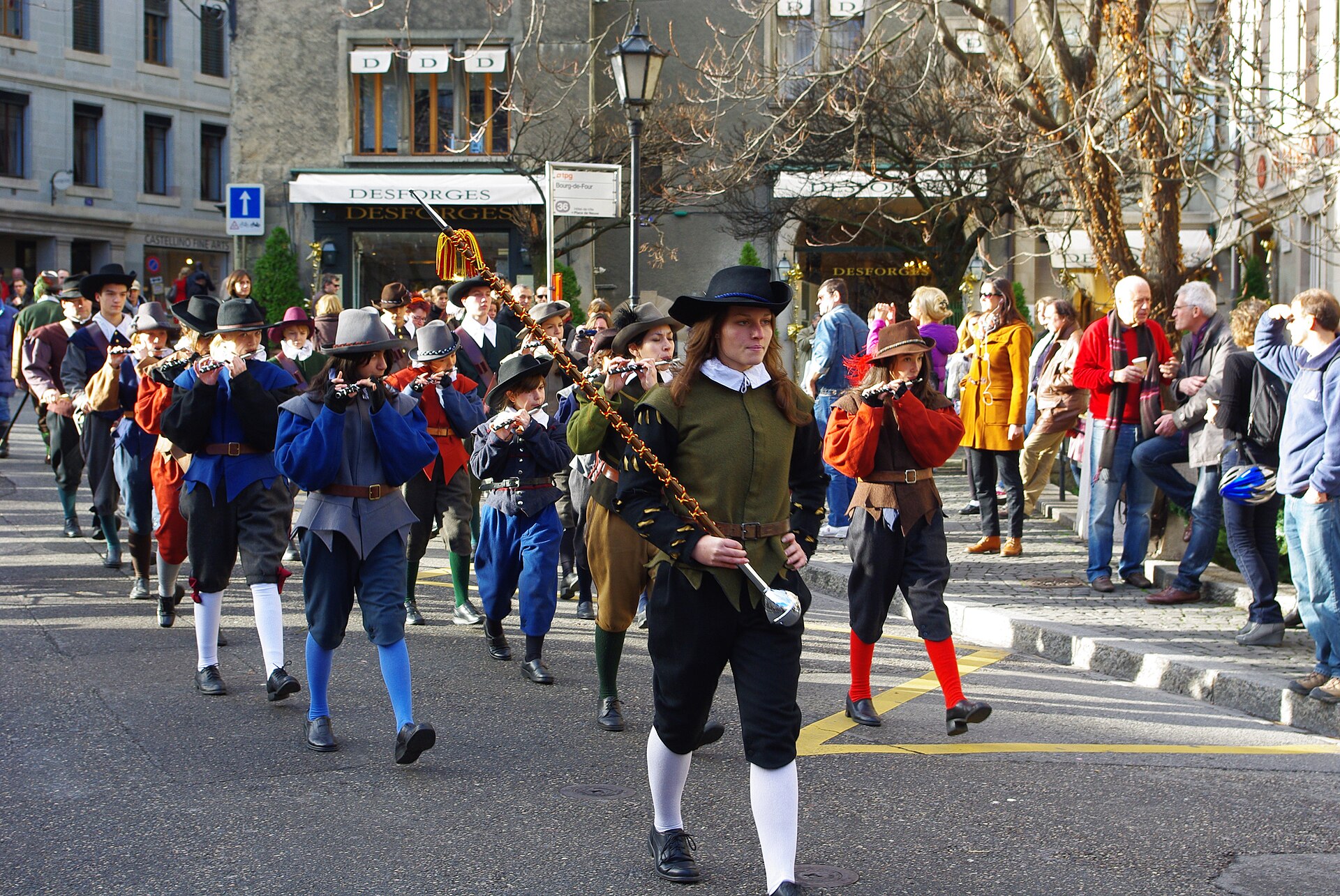 Costumed fifers follow a staff-carrying leader through Place du Bourg-de-Four during Geneva's Escalade celebrations.